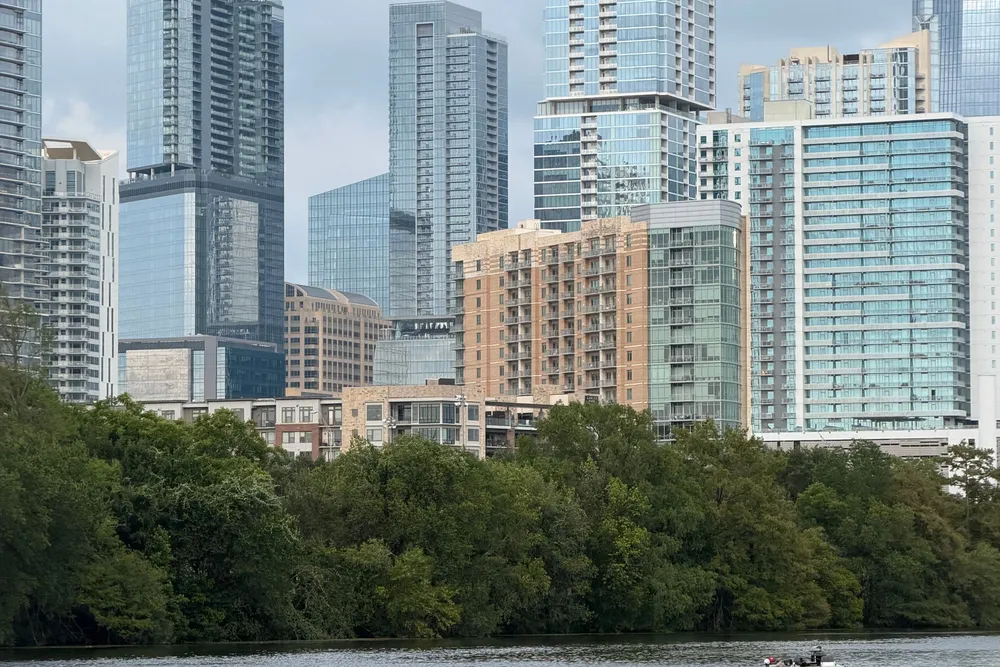 Downtown Austin skyline above trees along Lady Bird Lake