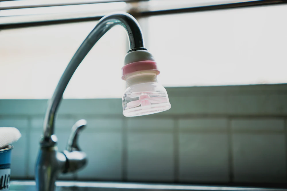 Water filter attached to a kitchen faucet over a sink
