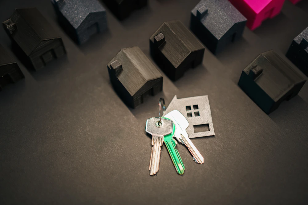 House keys beside small model houses, representing a new home